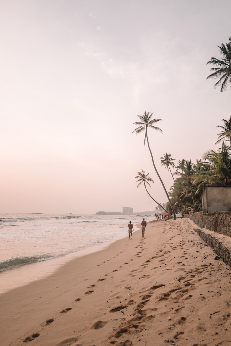 Couple walking along Unawatuna Beach in Sri Lanka